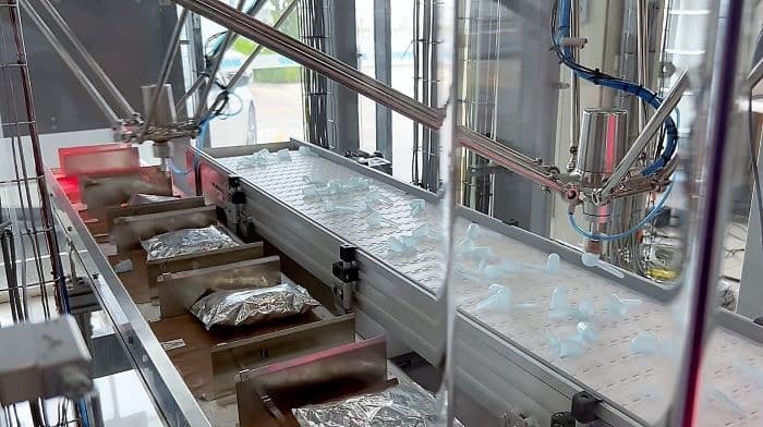 一部內建影像處理系統的攝影機,能偵測到輸送帶上量匙的位置,另一部則會偵測另一條輸送帶上的包裝袋位置。然後系統會計算出所需移動的距離與包裝袋精準的位置。圖 / KUKA提供