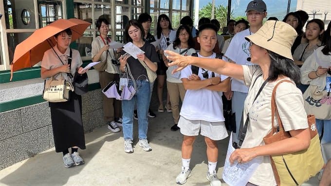 王珍珊博士(右一)向國際工作營師生介紹關山舊車站建築。圖 / 臺科大提供