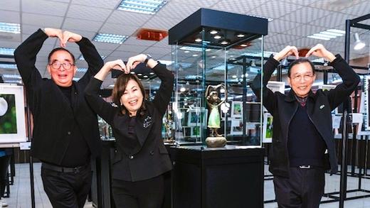 圖左起為麗明營造董事長吳春山、龍寶建設董事長張麗莉與生產力建設董事長張忠弘在展場，模仿創作雕塑雙手環頭高舉，開心比出大愛心，為今年巡迴首展留下歷史鏡頭。